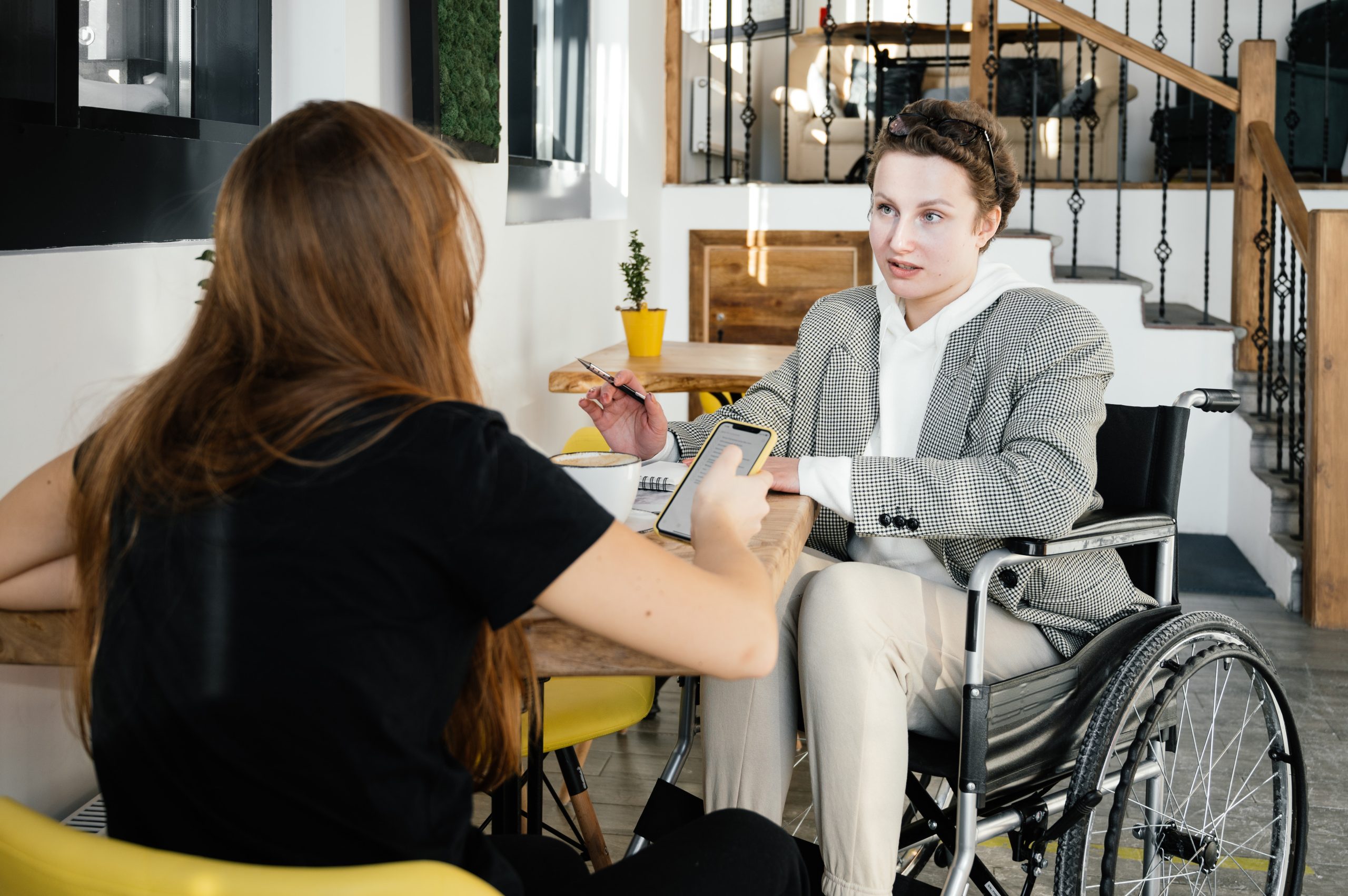 pexels-shvets-production-6980226 A woman shows her laptop to another woman with Down syndrome