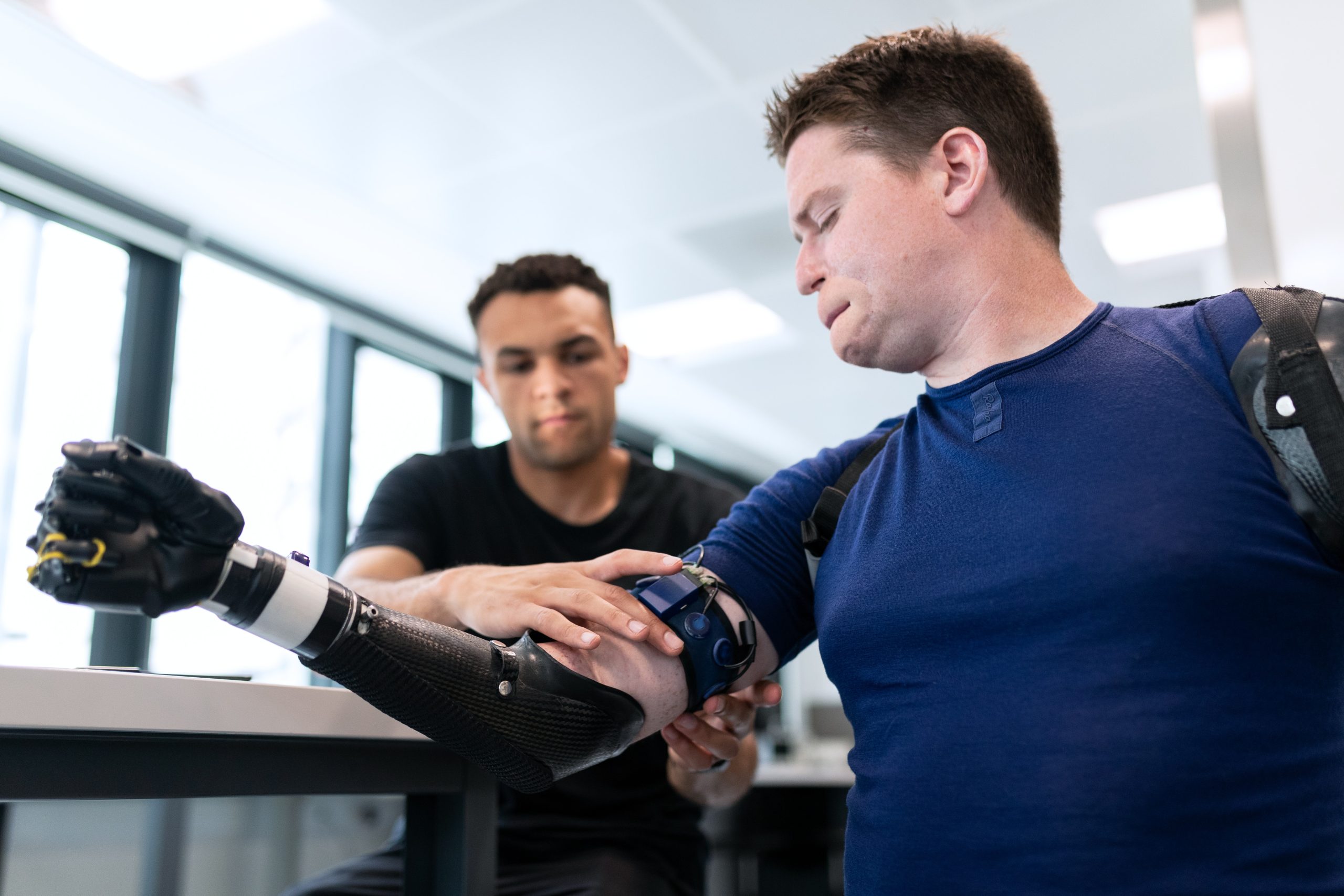 pexels-thisisengineering-3912950 A technician fits a man with a prosthetic arm