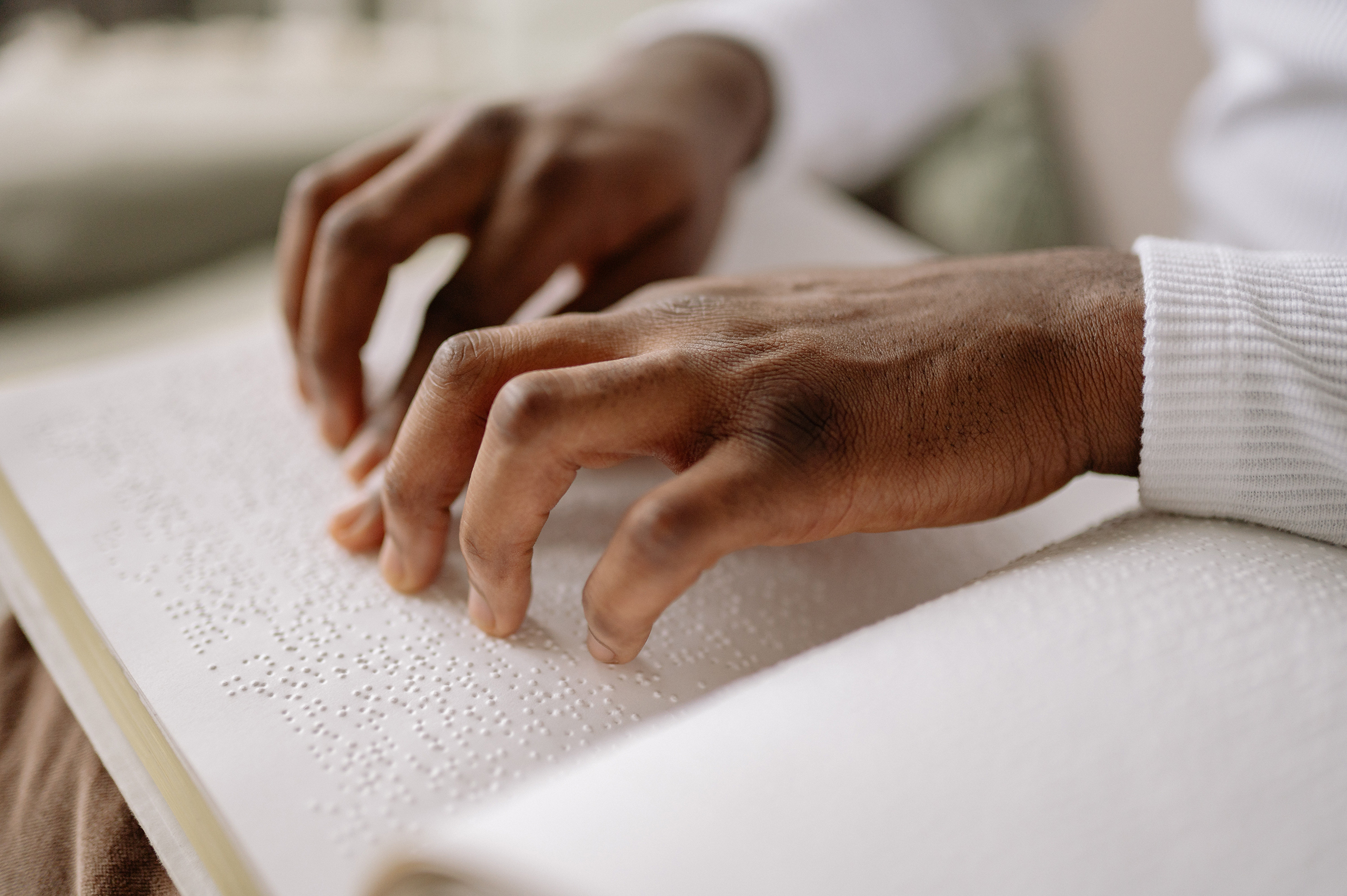 pexels-yan-krukov-7694420 Close up photo of a man's hands reading a Braille book